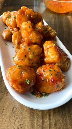 a white plate topped with chicken wings covered in sauce