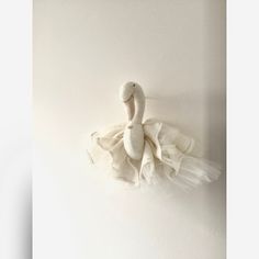 a white swan hanging on the wall with tulle skirt around it's neck