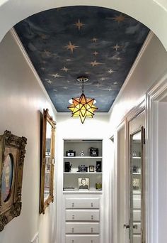 the hallway is decorated in white and blue with stars painted on the ceiling above it