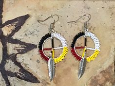 Authentic Beautiful Native American Indian Jewelry Navajo Zuni Hand Beaded Earrings Medicine Wheel with feathers. Great for a gift❤️ Handcrafted by Navajo Artist R. Sellers Present in virtually every Native American tribe, the feather symbol is universally recognized as a representation of trust, strength, wisdom, freedom, and honor. Incorporated into many sacred pieces of Native American wear, the feather is easily one of the most respected symbols. The Medicine Wheel, sometimes known as the Sa Four Directions Medicine Wheel, Native American Beaded Earrings With Quills, Beaded Medicine Wheel, Native American Hoop Earrings Beadwork, Native Indian Jewelry, Beaded Medicine Wheel Earrings, Native American Dentalium Earrings, Native American Medicine Wheel, Native American Beadwork Earrings