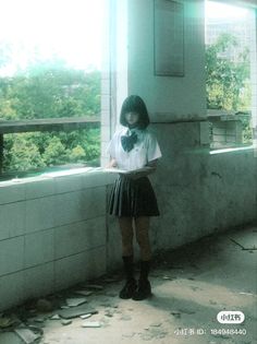 a girl standing in front of a window with her hands on her hips and looking down