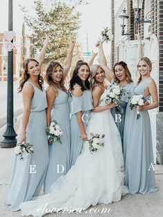 a group of women standing next to each other in front of a light pole with flowers