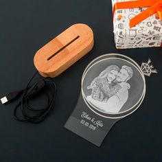 a couple's photo on a glass plate next to a small wooden box with an orange ribbon