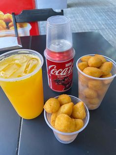 three plastic cups filled with food sitting on top of a table next to a drink