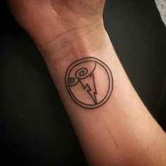 a small tattoo on the wrist of a person with a lightning bolt and circle around it