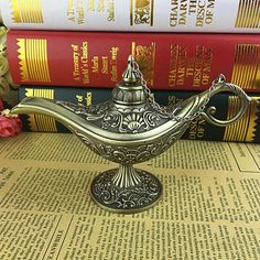 a silver teapot sitting on top of a table next to books