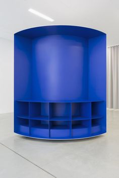 a round blue shelf in an empty room