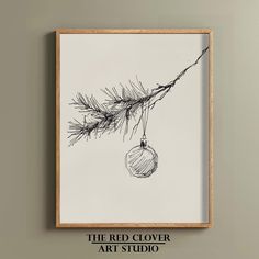 the red clover art studio's christmas ornament hangs from a pine tree branch