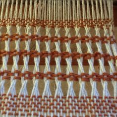 an orange and white weaving pattern on a loom