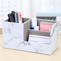 a white marble desk organizer with pens, pencils and other office supplies in it