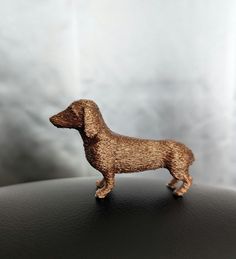 a toy dachshund dog standing on top of a table