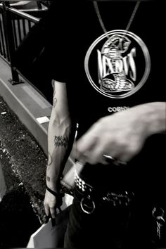 a man with tattoos on his arm walking down the street