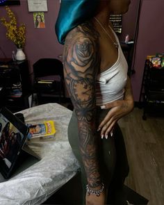 a woman with tattoos on her arm and leg