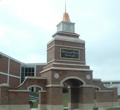 a large brick building with a clock tower in the middle of it's entrance