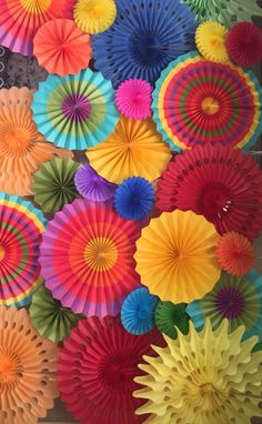 many different colored paper fans are arranged together