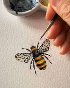 a drawing of a bee on paper with a paintbrush in it's left hand