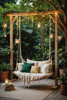 a porch swing with lights hanging from the ceiling and pillows on the ground in front of it