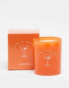 an orange candle in front of a box