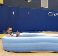 a man sitting in an inflatable pool holding a beer