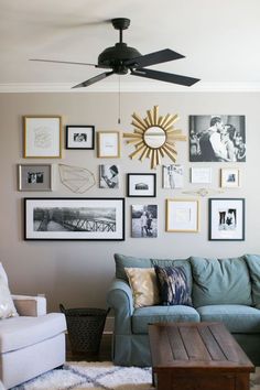 a living room with pictures on the wall and a ceiling fan in front of it