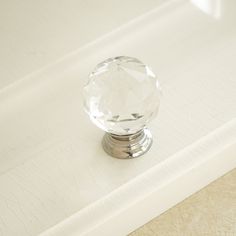 a clear glass door knob on a white surface