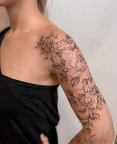 a woman's arm with flowers on it, and the back of her shoulder