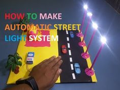 a hand is holding a piece of paper with cars on it and the words how to make automatic street light system