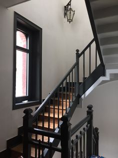 the stairs are black and white in this room with a light fixture on the wall