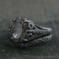 a close up of a ring with a stone in the center on a table top