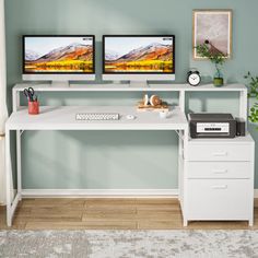 two computer monitors sitting on top of a white desk