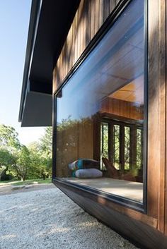 an open window on the side of a building with wood sidings and glass doors