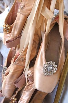 there are many ballet shoes hanging on the rack