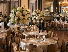 the tables are set with gold and white centerpieces