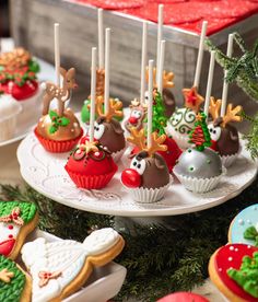 decorated christmas cupcakes and cookies are on display in front of other desserts