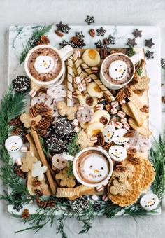 christmas dessert board with cookies, hot chocolate and marshmallows on it in the middle