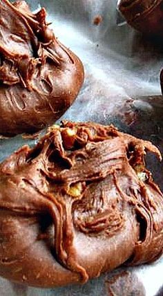 two chocolate cookies are sitting on a metal pan with some frosting in the middle