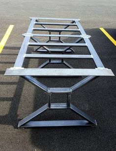 an empty parking lot with two metal benches on it and yellow lines in the background