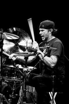 a man sitting in front of a drum set on top of a drumset and holding a pair of sticks