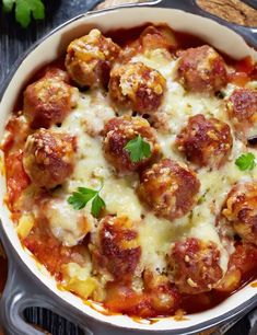 a casserole dish with meatballs and cheese in it on a wooden table