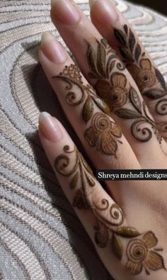 a woman's hand with henna tattoos on it