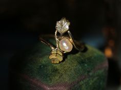 This lyrical Art Nouveau ring by René Lalique is designed around two greenish champleve-enameled leaves gently embracing a natural baroque pearl- depicting an early autumn scene with an acorn and oak leaves just in the process of turning yellow. (In the closeup shots, you can see how he masterfully captured the green leaves gradually turning yellow with subtle golden hue.) Nature and four seasons had been a central theme for Lalique's creations, which is artistically crystalized in this Art Nouveau ring dating from circa 1900.  Signed  "Lalique" and makers mark stamped. Another version of this design by René Lalique featuring a button pearl and enameled leaves is stocked in Hashimoto collection , being pictured in 'Historic Rings' by Diana Scarisbrick  (See pic.10)  Pearls were the favorit Art Nouveau Ring, Acorn And Oak, Mighty Oaks, Celtic Symbols, Life Symbol, Autumn Scenes, Early Autumn, Oak Leaves, Ancient Jewelry