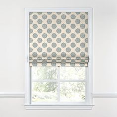 a window with a blue and white patterned roman blind on it's valance