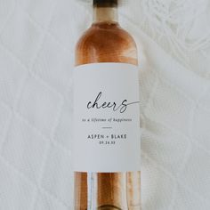 a bottle of wine sitting on top of a white cloth covered tablecloth with a label that says the wedding of ardlee and stevens