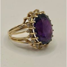 This is part of Chairish’s Fine Jewelry assortment.  14k yellow gold cocktail ring featuring a deep purple/red/blue oval amethyst, encircled by 16 small diamonds.  Ring Size: 6 in. Stone: 16.42 x 12.40 x 8.7 mm Ring Weight: 6.7 grams  If you would like more information, please contact me via email, mrboult@gmail.com. Yellow Gold Cocktail Ring, Green Pendant, Amethyst And Diamond Ring, Green Pendants, Gold Cocktail Ring, Gold Cocktail, Diamonds Ring, Diamond Cocktail Rings, Purple Stones