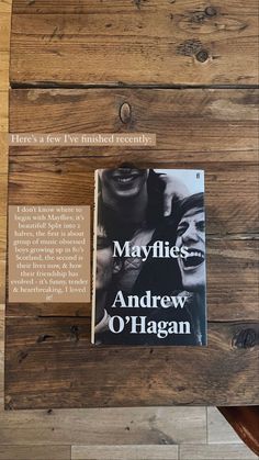 the book mayflies by andrew o'hagan is displayed on a wooden table