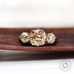 three diamond rings sitting on top of a wooden table