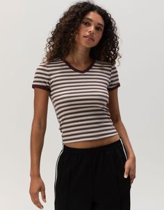 Full Tilt V-Neck Baby Tee. Ribbed Knit Construction. Allover Stripe Print. V-Neckline. Short Sleeve. Shrunken Fit. 57% Cotton, 38% Polyester, 5% Spandex. Machine Wash. Imported. Model Is Wearing A Size Small. Model Measurements:height: 5'7" Bust: 32cwaist: 24"hips: 35" Ribbed Cotton V-neck T-shirt, Sporty Striped V-neck Top, Sporty Fitted Top With Ribbed Neckline, Fitted Striped Ribbed T-shirt, Striped Stretch V-neck Top, Ribbed V-neck Elastane Top, Sporty Tops With Ribbed Neckline And Stretch Fit, Sporty Stretch Top With Ribbed Neckline, Stretch V-neck Tops With Ribbed Neckline