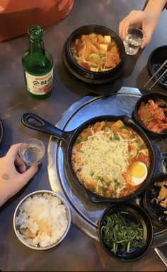 a table topped with lots of different types of food next to bottles of beer and glasses