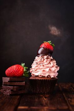 two chocolate cupcakes with strawberries on top