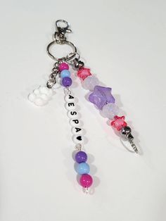 a keychain with beads and charms attached to it on a white table top